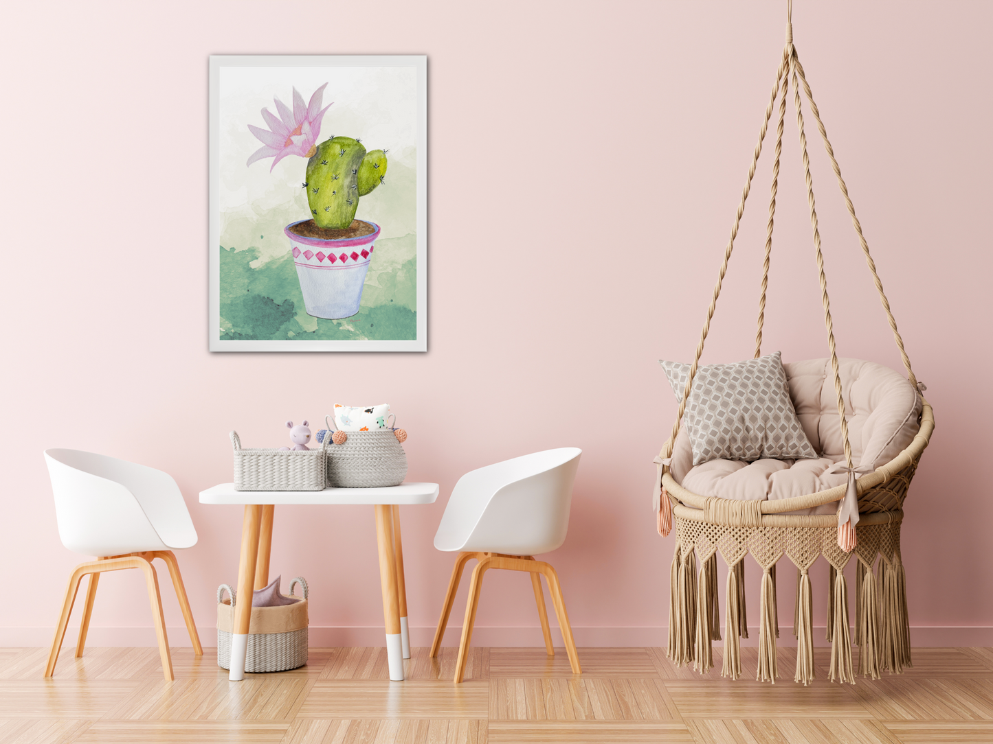 Children's room with a pink wall, wicker chair, and white chairs. The cactus artwork is displayed on the pink wall above the table and chair set. 