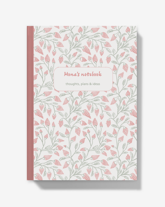 A notebook with a white cover decorated with a repeating pattern of pink flowers and green leaves, featuring a pink spine and a central label that reads 'Mona's notebook' and 'thoughts, plans & ideas'.