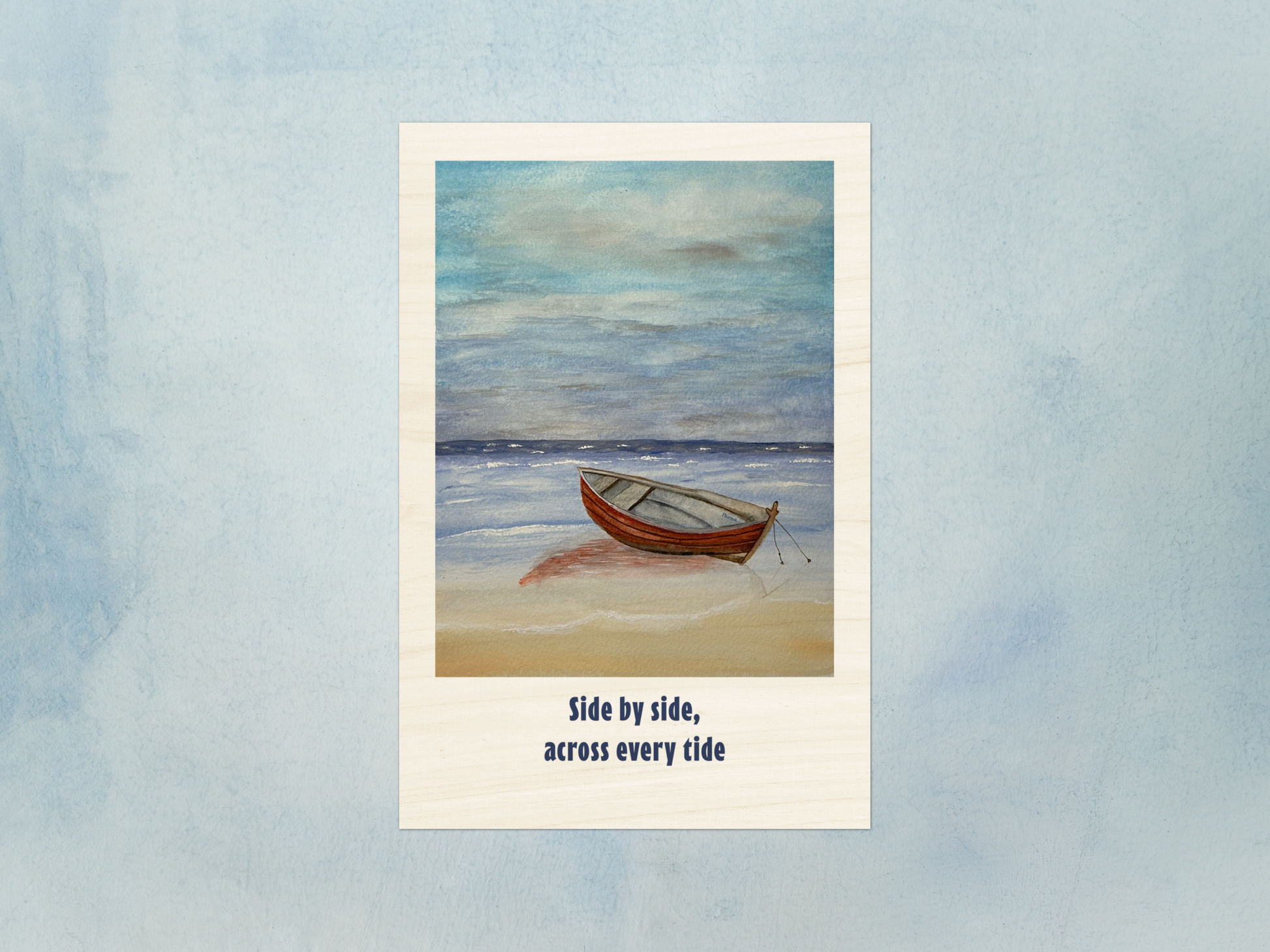 A vertical art print featuring a painted scene of a small red boat on a sandy beach under a cloudy blue sky, with the text 'Side by side, across every tide' below the artwork, shown against a textured light blue background.