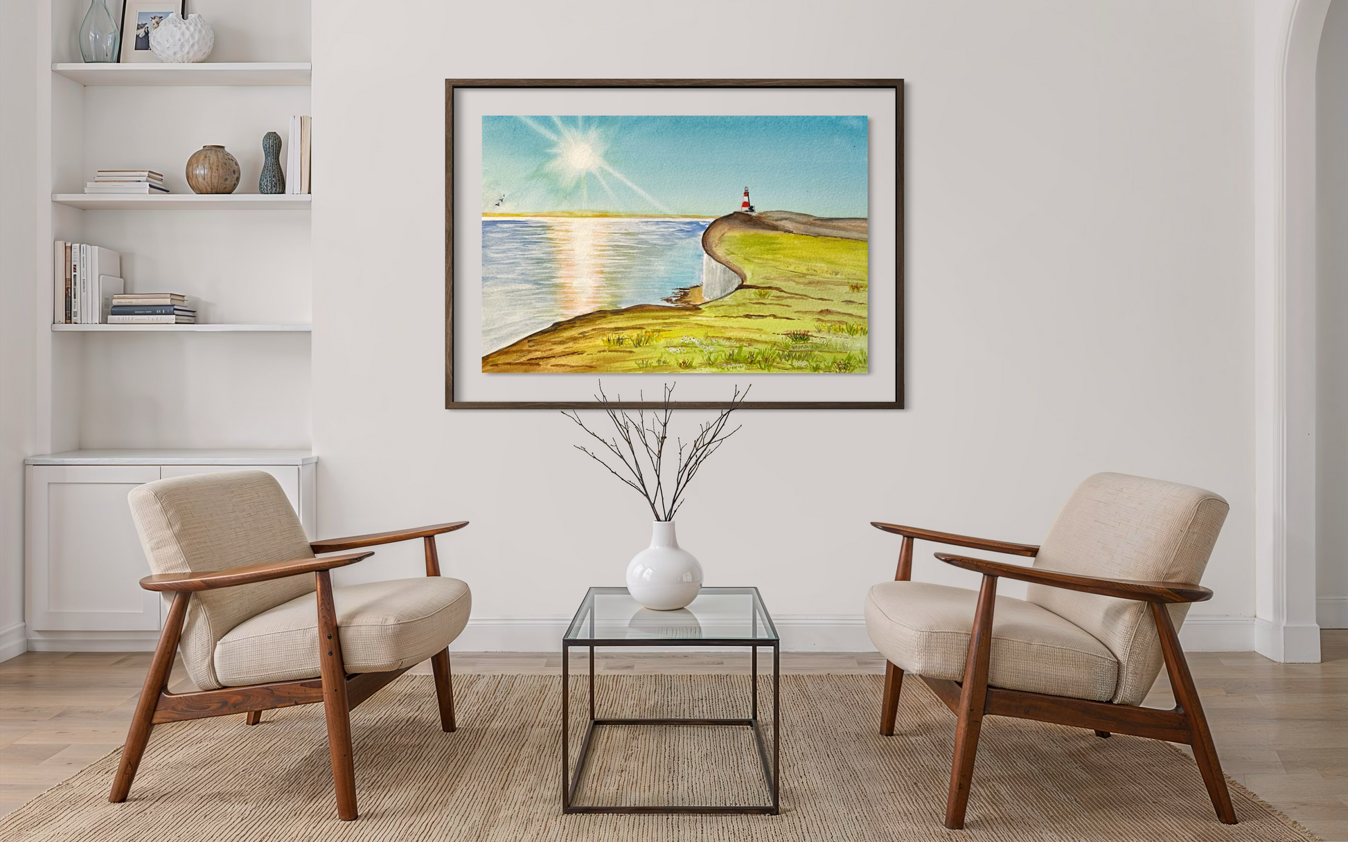 Living room with two armchairs and a glass coffee table, featuring a framed artwork of a lighthouse on a wall.