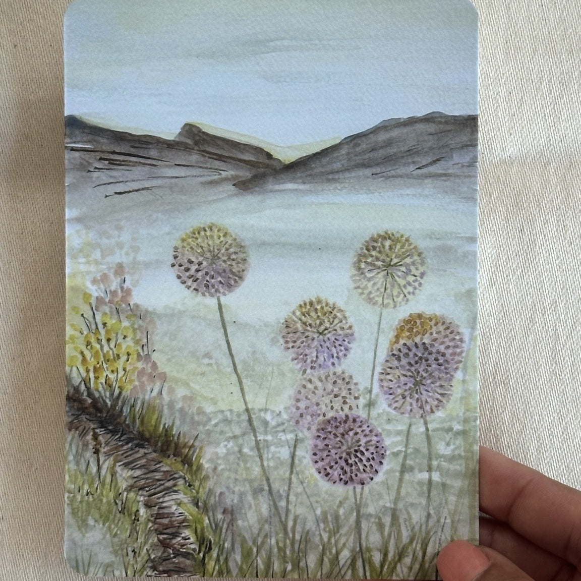 At Summer's End watercolour postcard held in hand