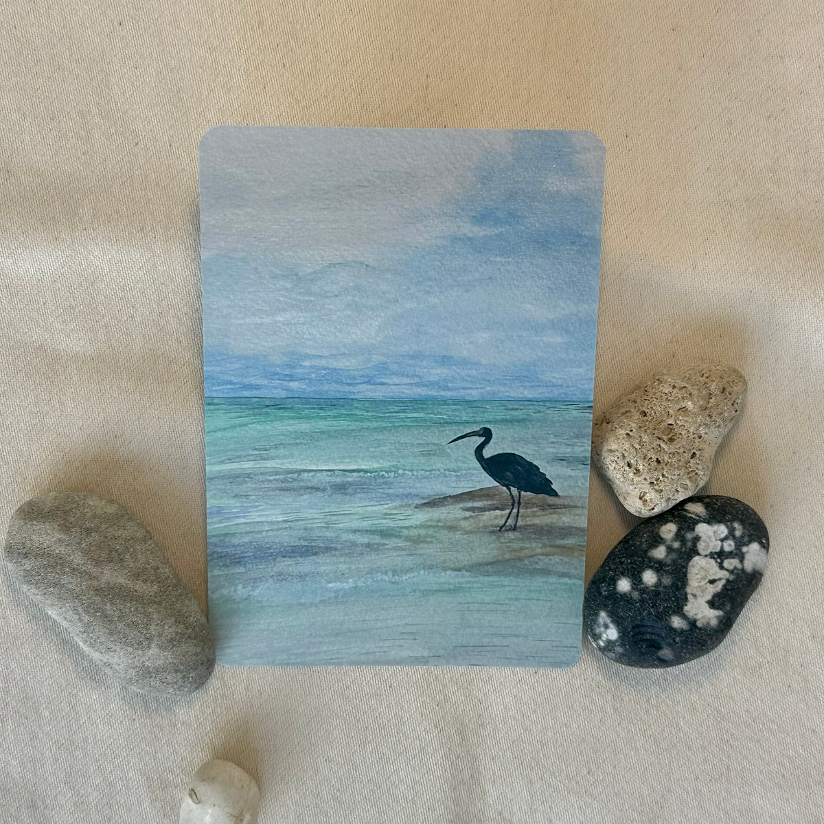 Crane in Cancun watercolour postcard styled with beach stones
